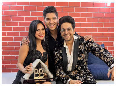 "Bigg Boss 19 winner Gaurav Khanna posing with wife Akanksha Chamola and friend Mridul Tiwari holding the trophy."